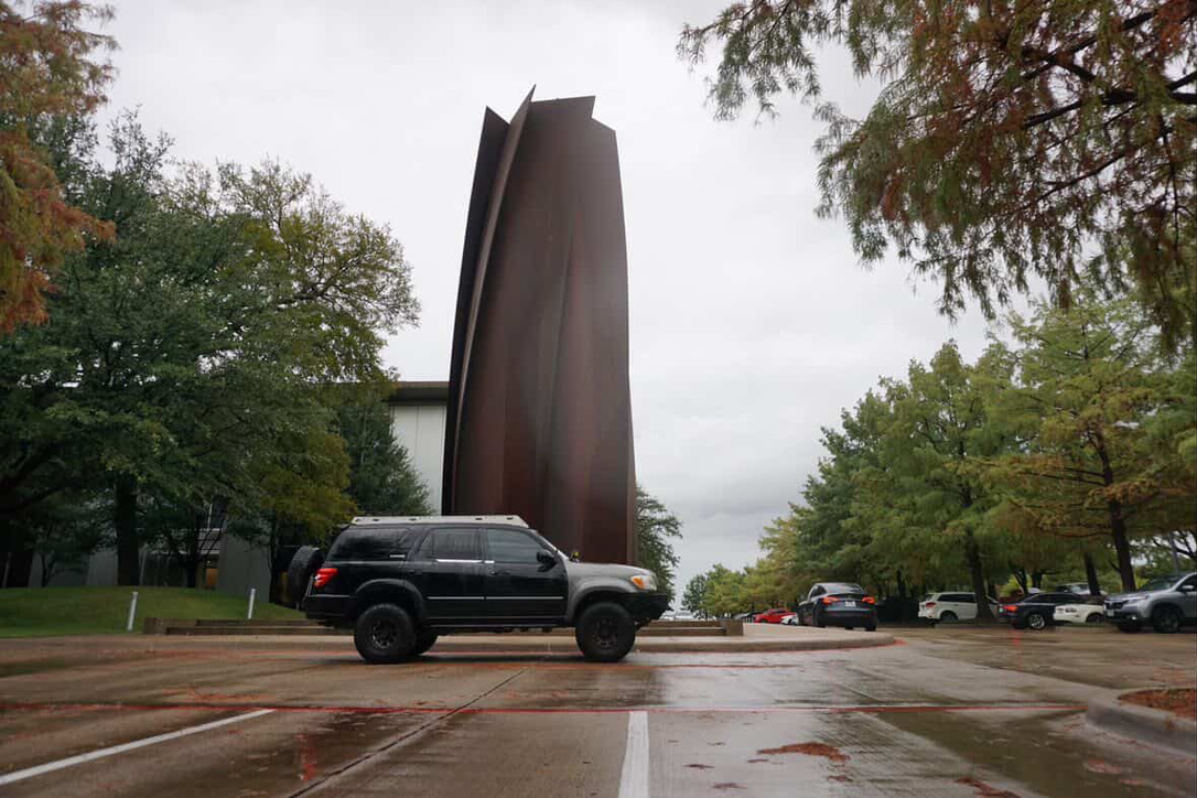 Black lifted Toyota Sequoia in front of a sculpture
