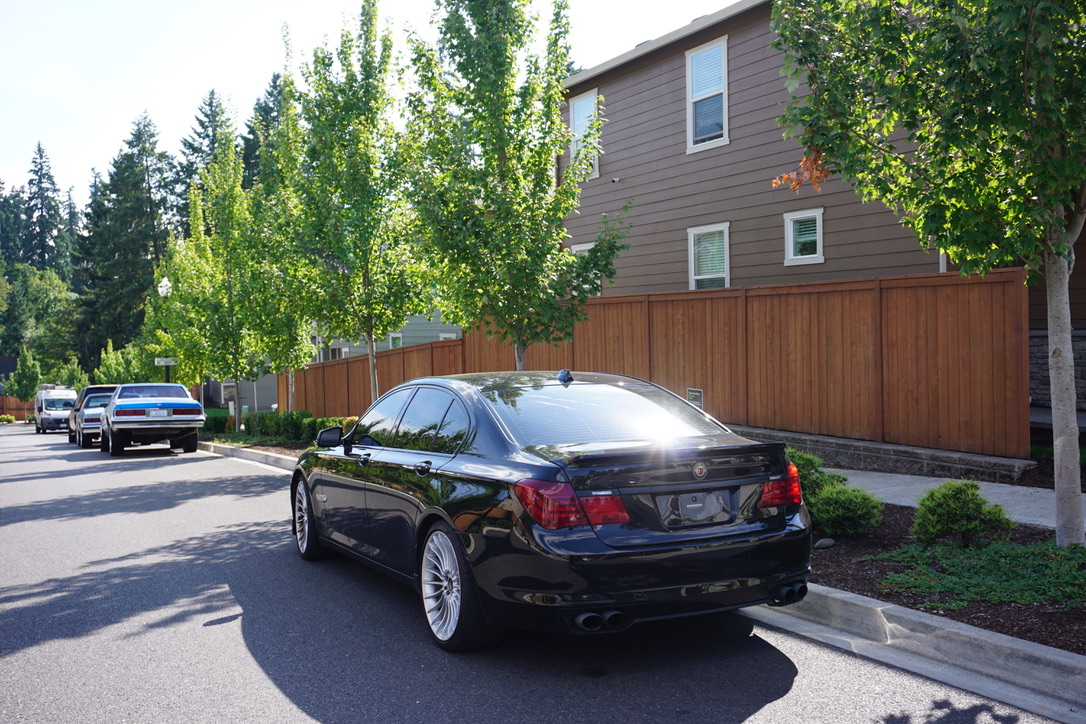 Black BMW Alpina B7 parked on a tree-lined street